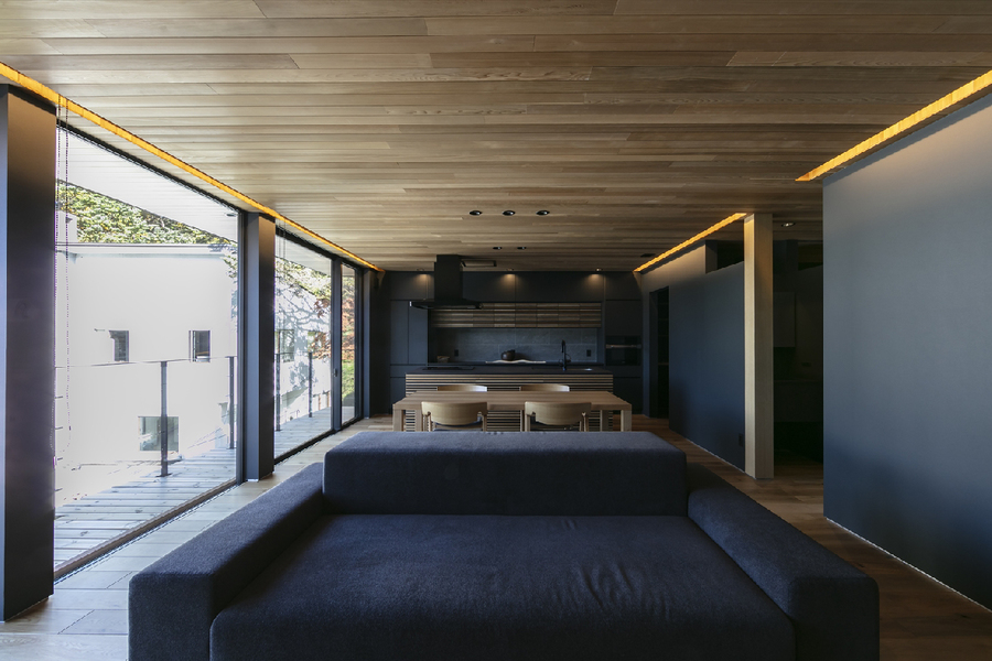 レッドシダーの羽目板に黒の壁紙、造作家具で設えた内装。大開口リビング。